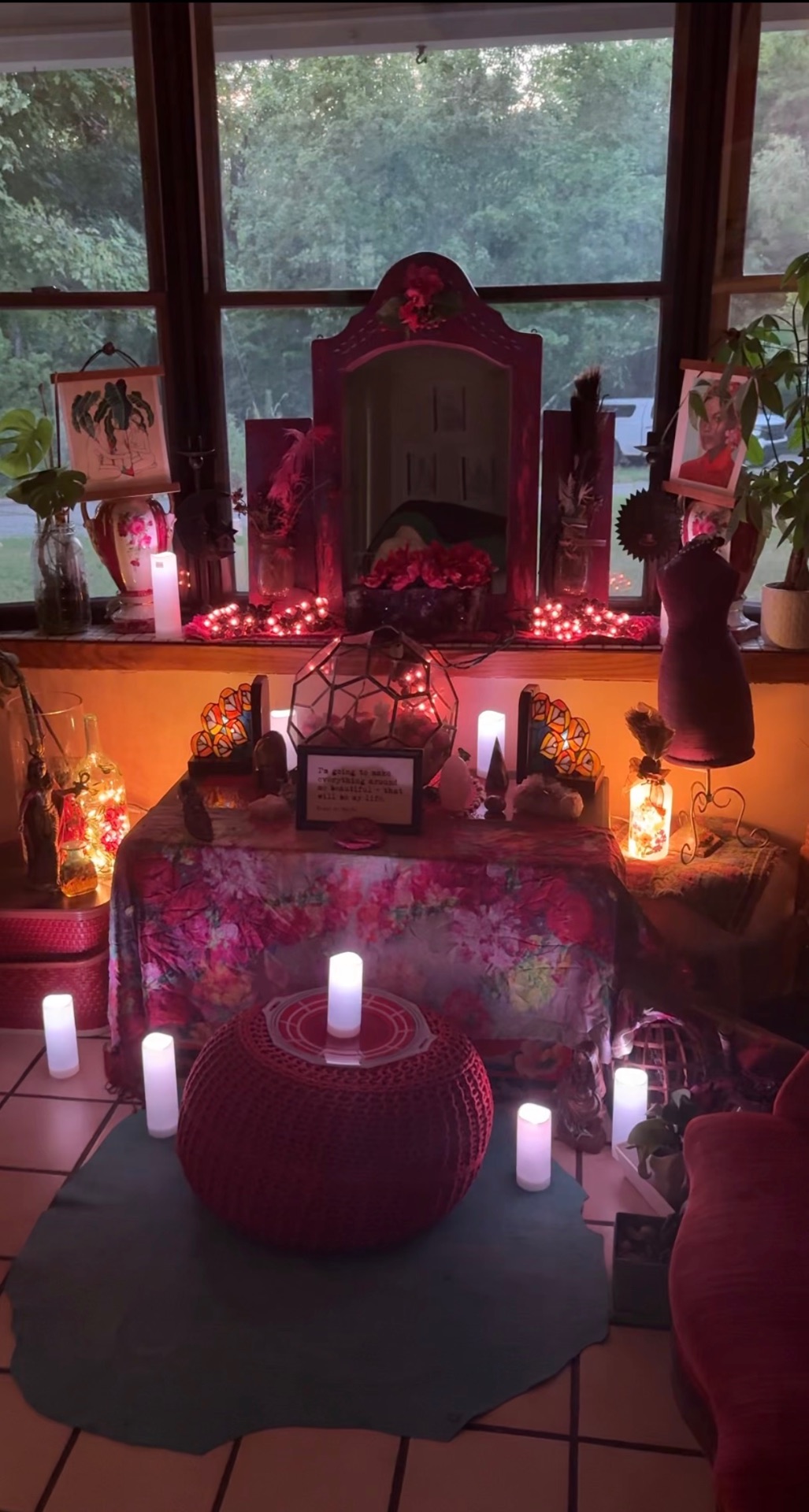 Reverent Mariela's candlelit altar of flowers, mirrors and warm light